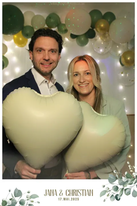 Zwei Hochzeitsgäste mit Herzballons im weißen Fotolayout mit Eukalyptus, Namen und Hochzeitsdatum