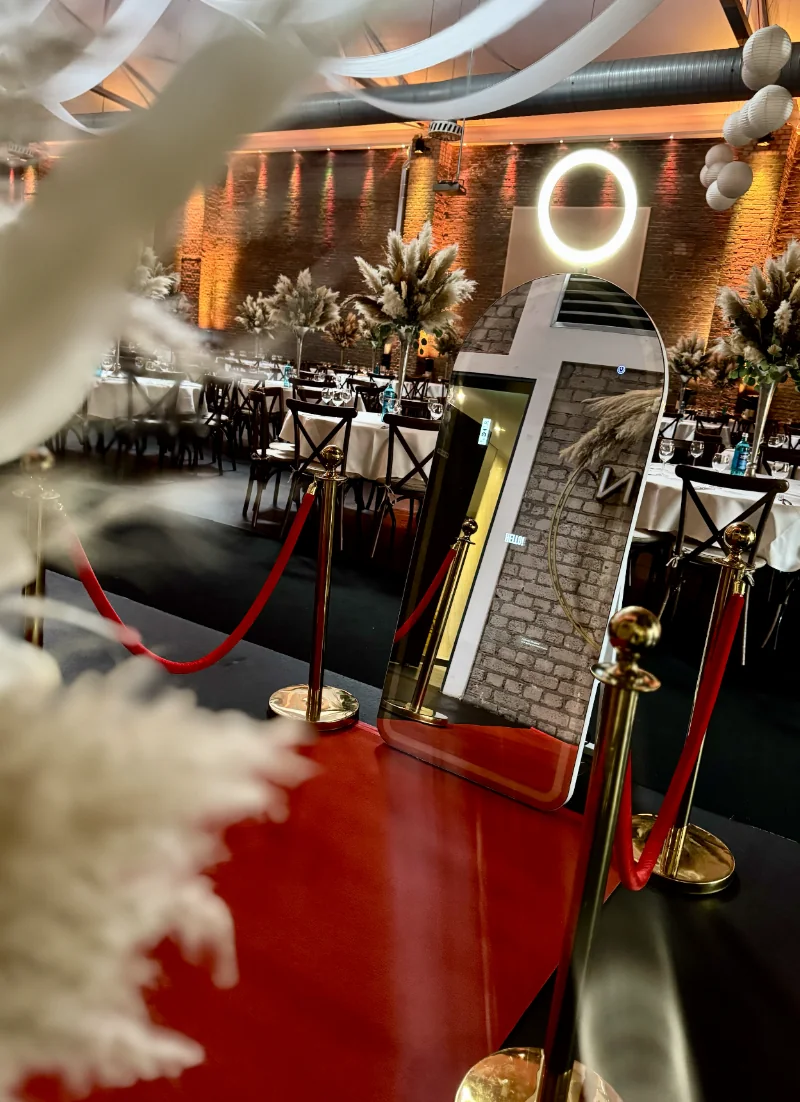 Fotospiegel neben festlich gedeckten Tischen und Pampasdekoration in einer Eventlocation